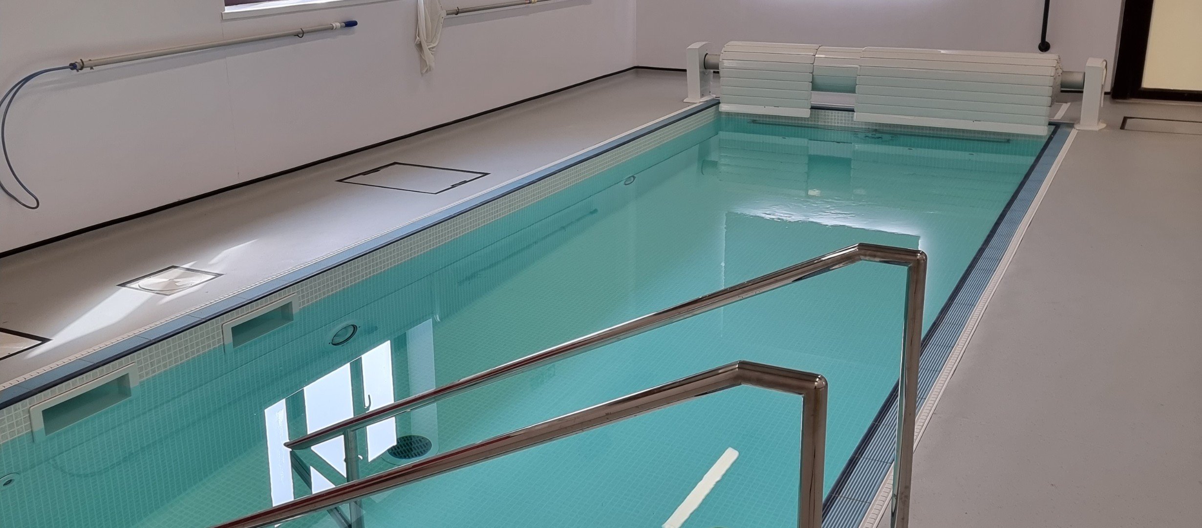 image shows a long narrow pool with step access and wide walkways all around