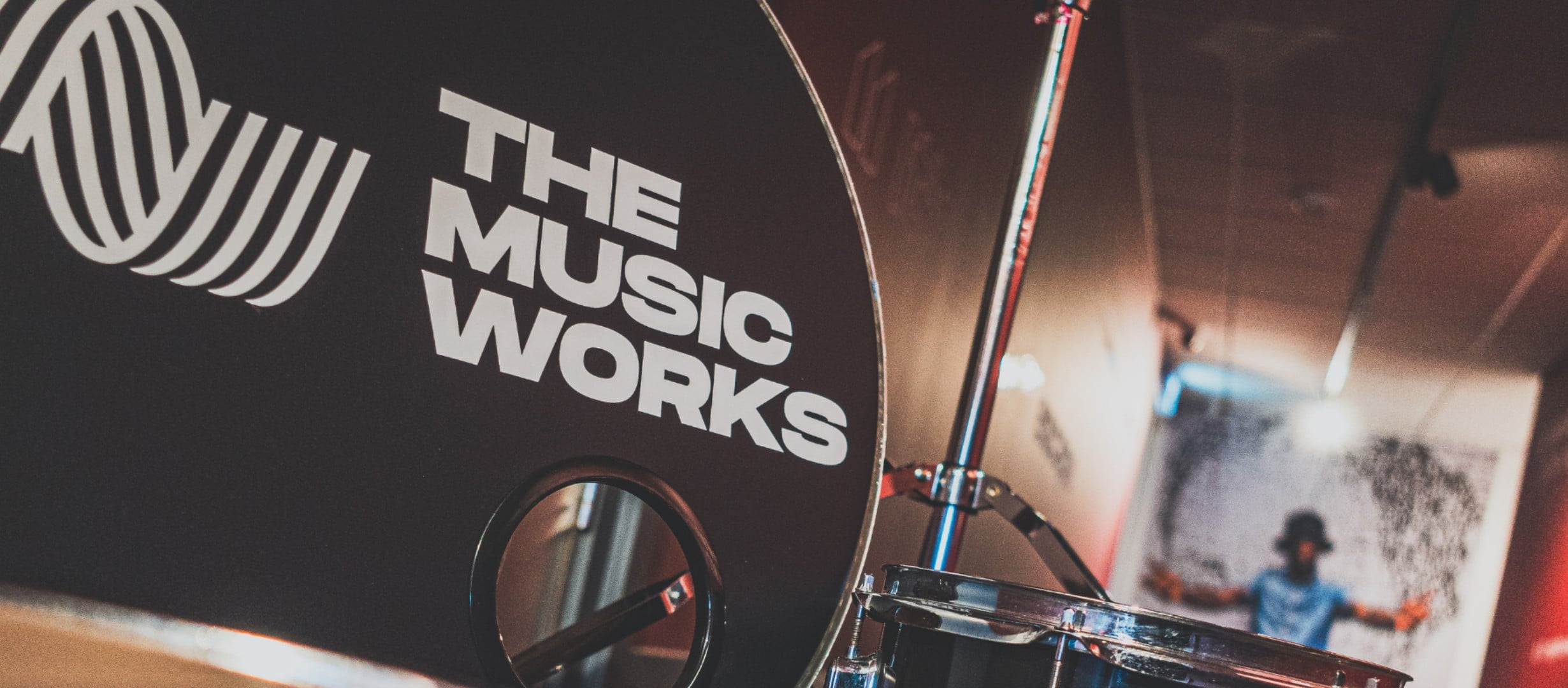 A close up of The Music Works logo on a drum kit in the corridor at the Hub in Gloucester