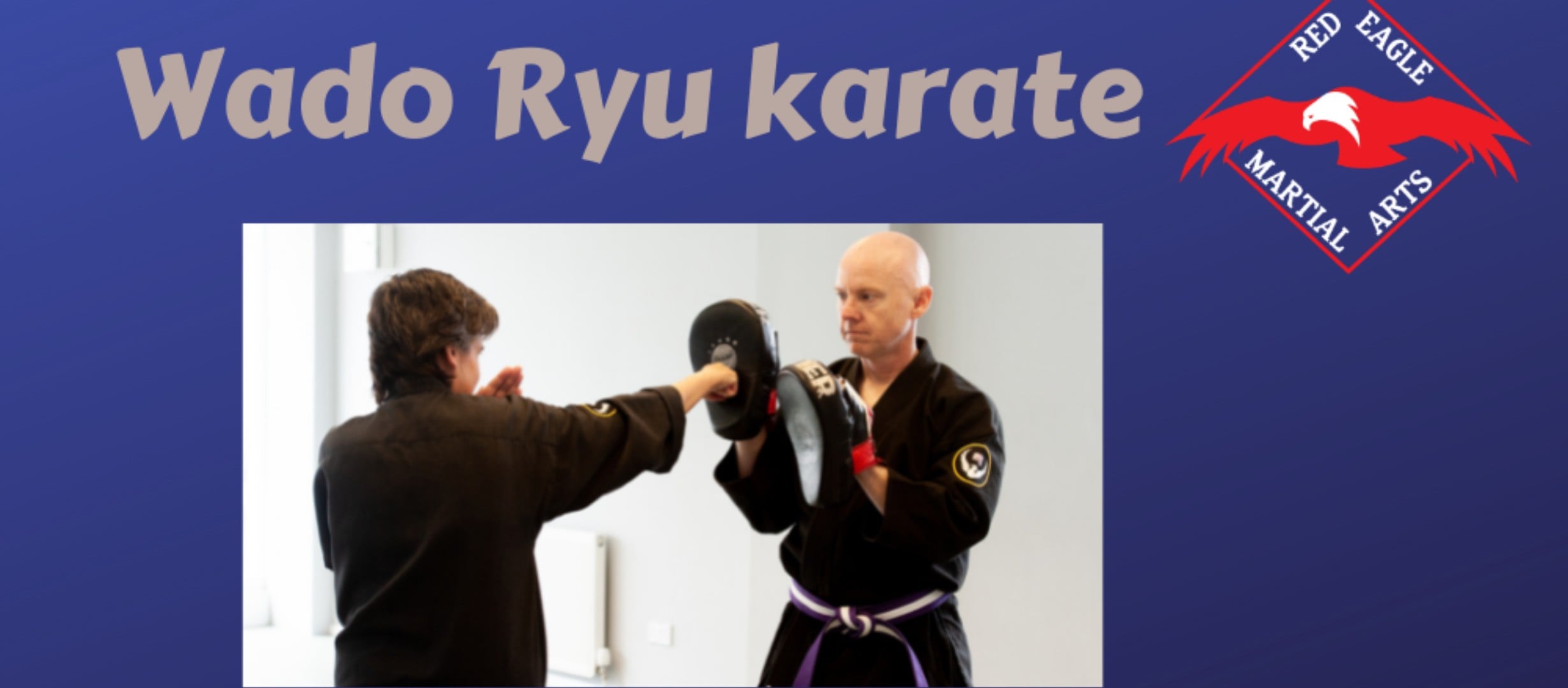 Adults practising punches on focus pads with a partner