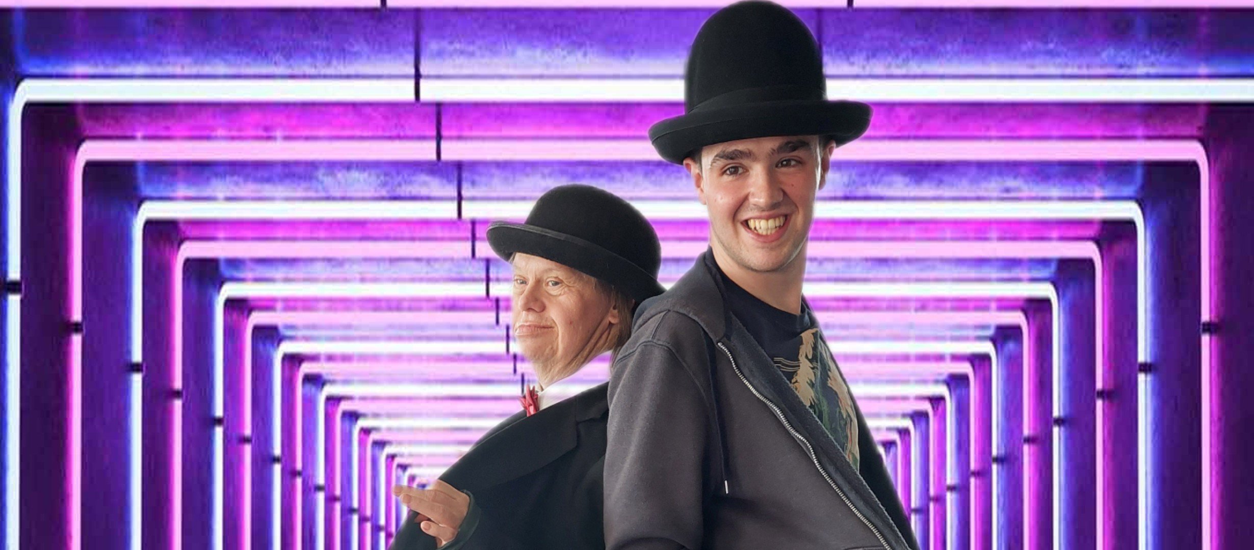 Actors dressed as Laurel and Hardy with a neon tunnel in background