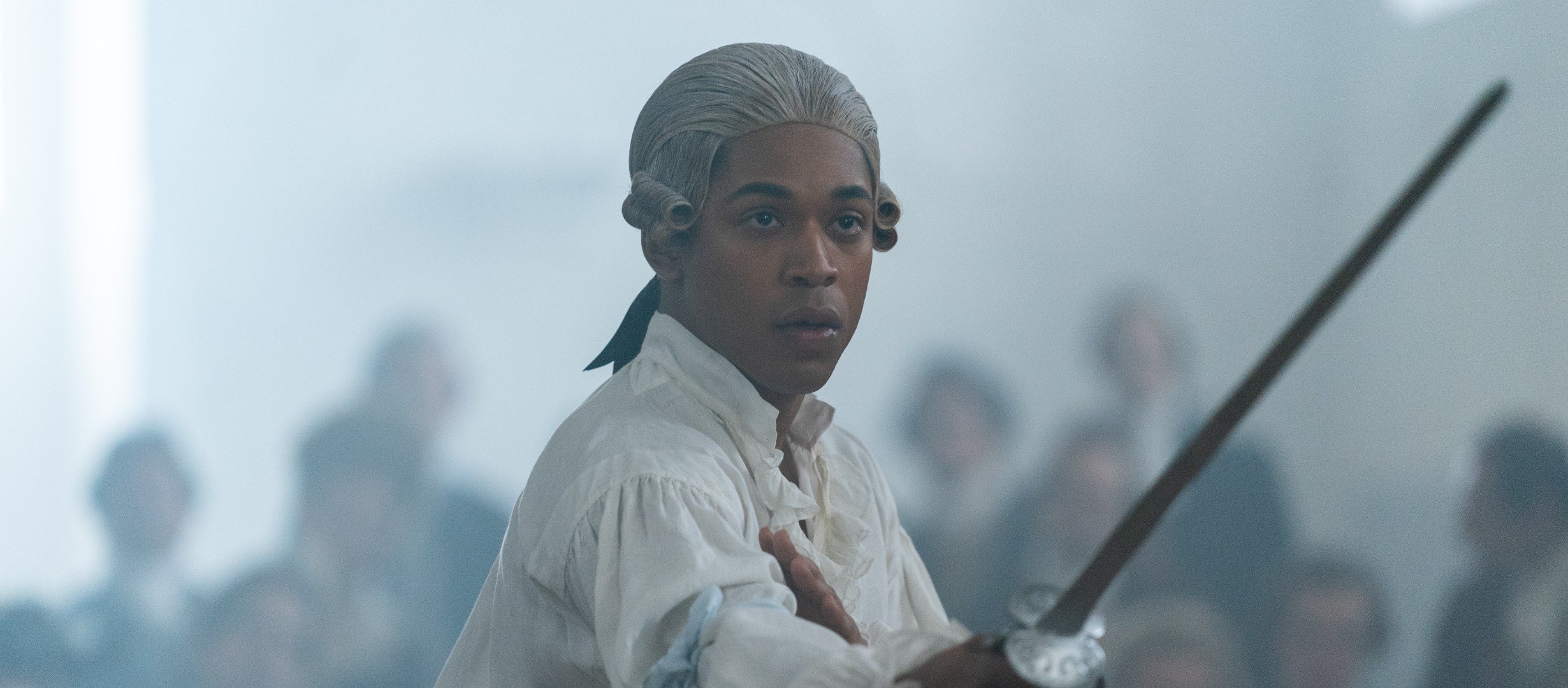 A man in 18th century attire holding a sword