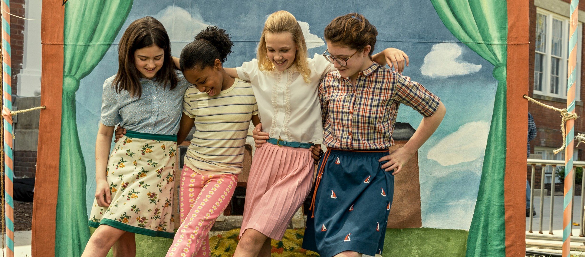 Four girls with their arms around eachother smiling