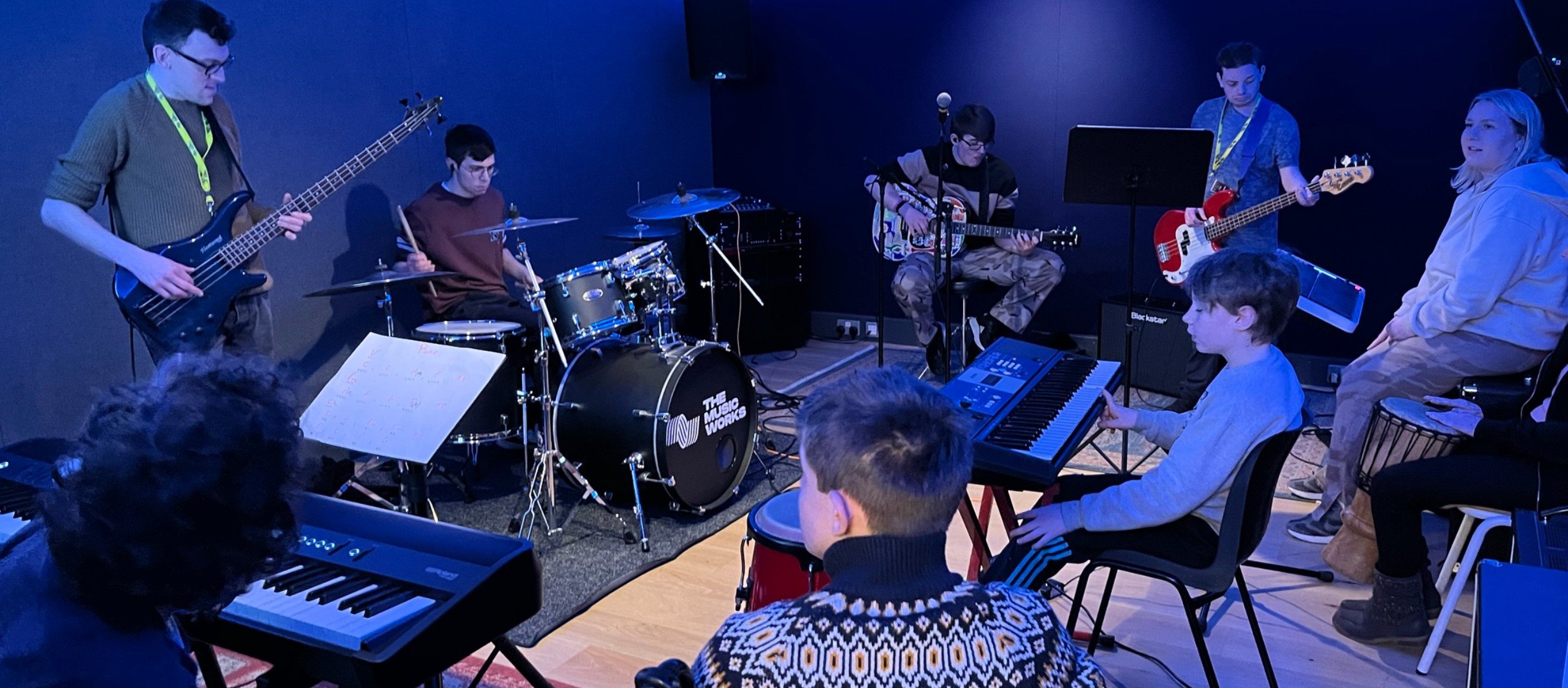 A group of young people in a circle playing a variety of instruments