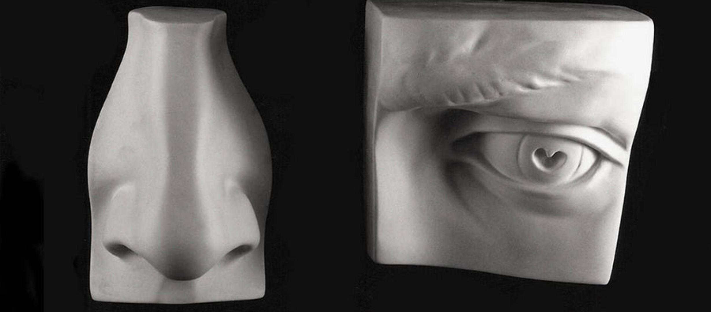 Black and white photograph of a sculpture of a nose and a sculpture of an eye