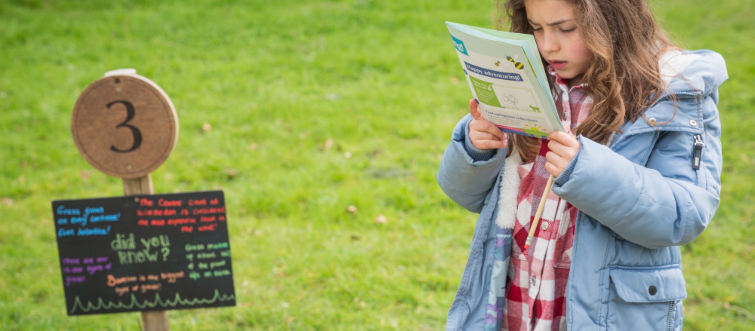 Child looks at a trail sheet in the garden