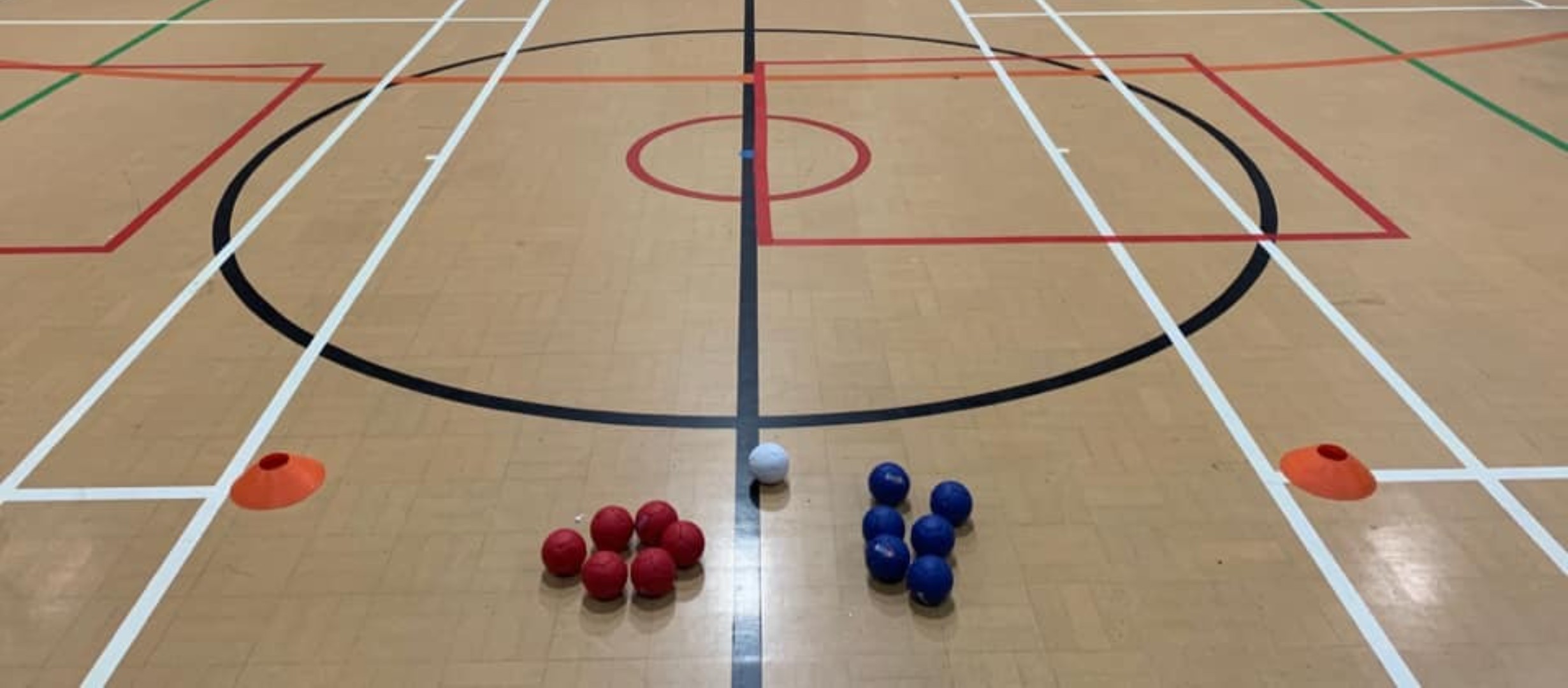 photo of sports hall floor with boccia balls and cones