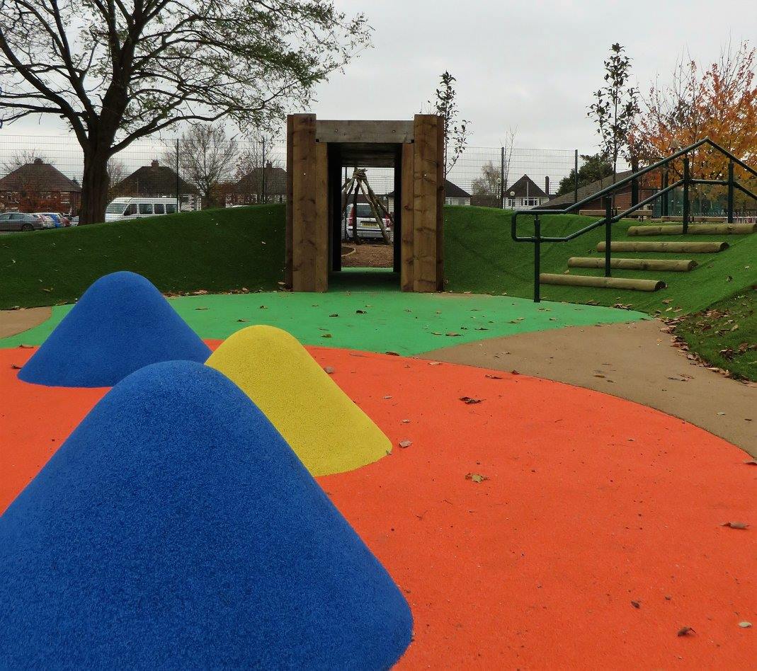 Picture of the Outdoor Adventure Playground. It is colourful, has slides, hidey holes, tracks and lots of sensory items.