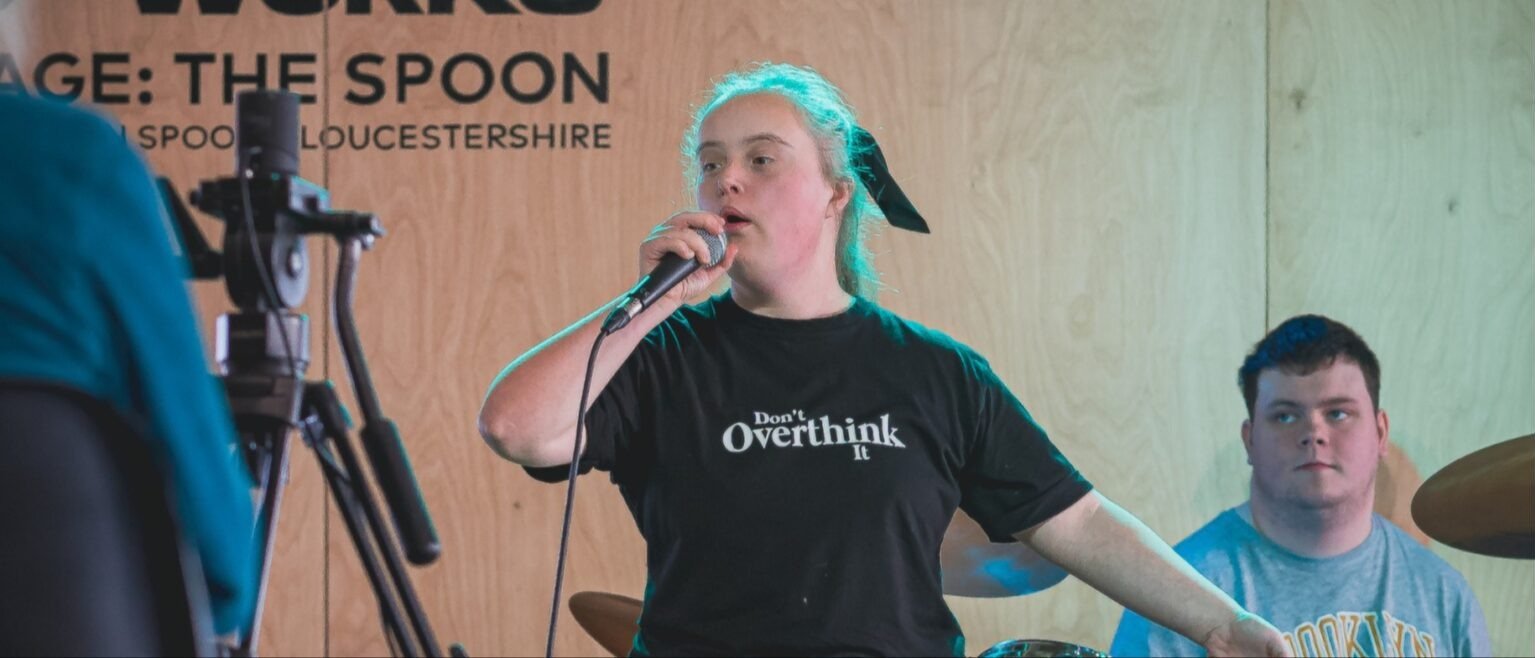 An image of a young woman singing on stage