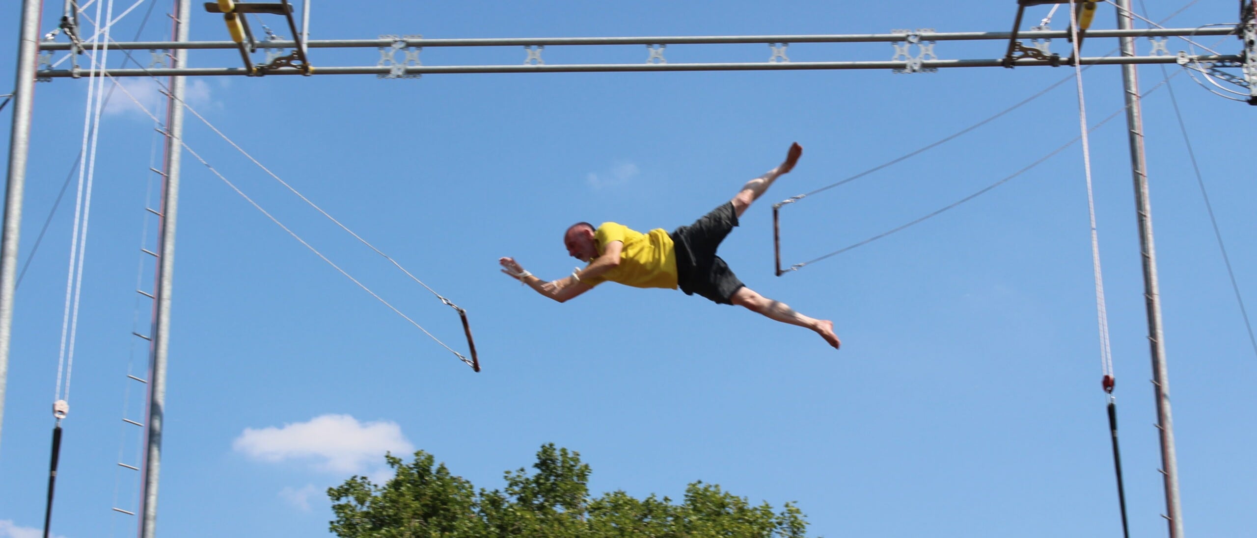 Flying Trapeze artist flying from one bar to catch another
