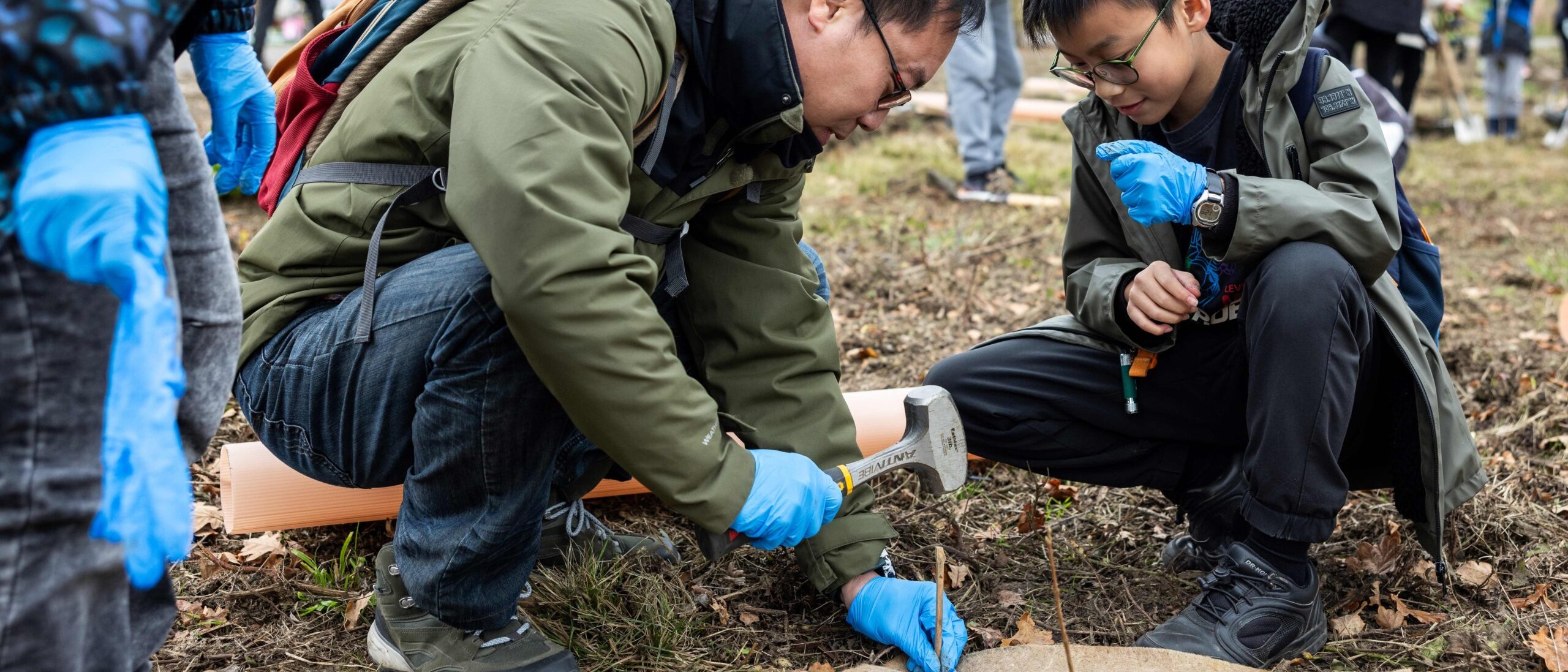 adult and child planting tree outside