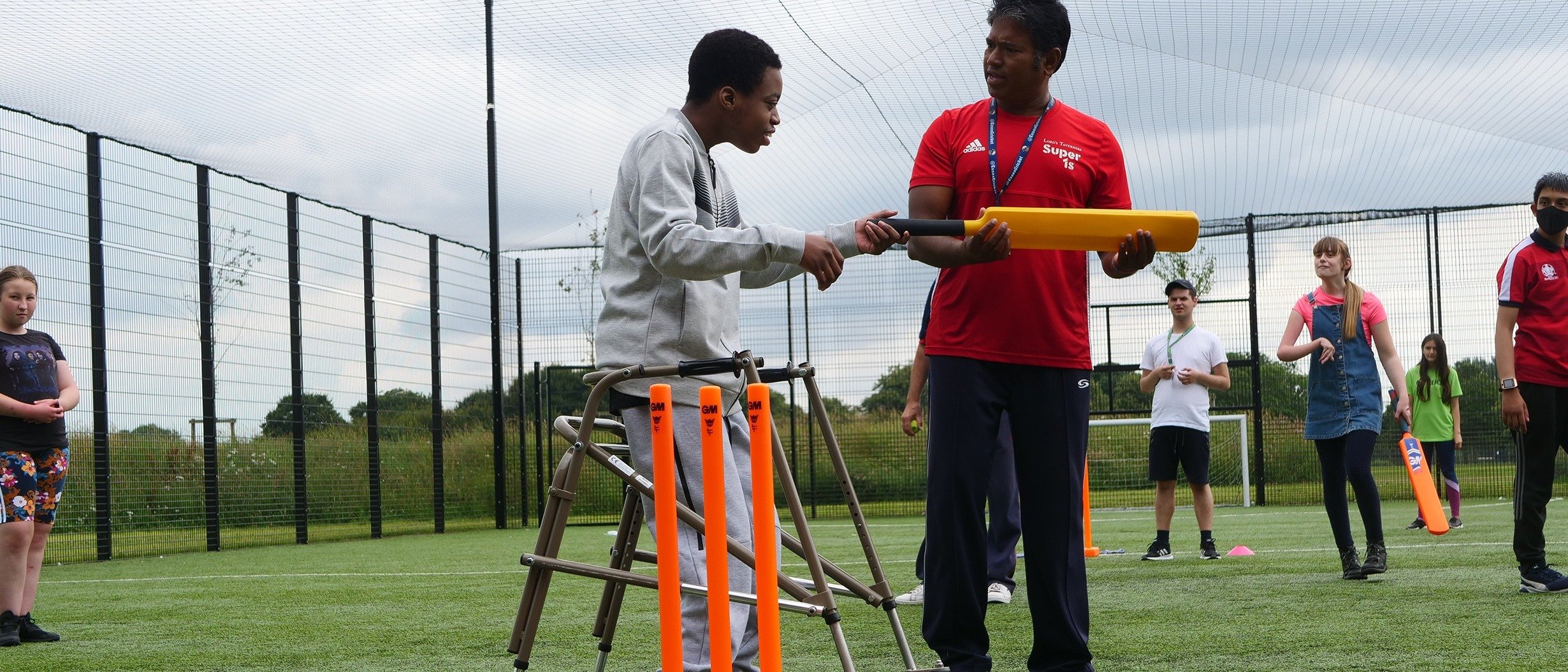 Young people playing cricket