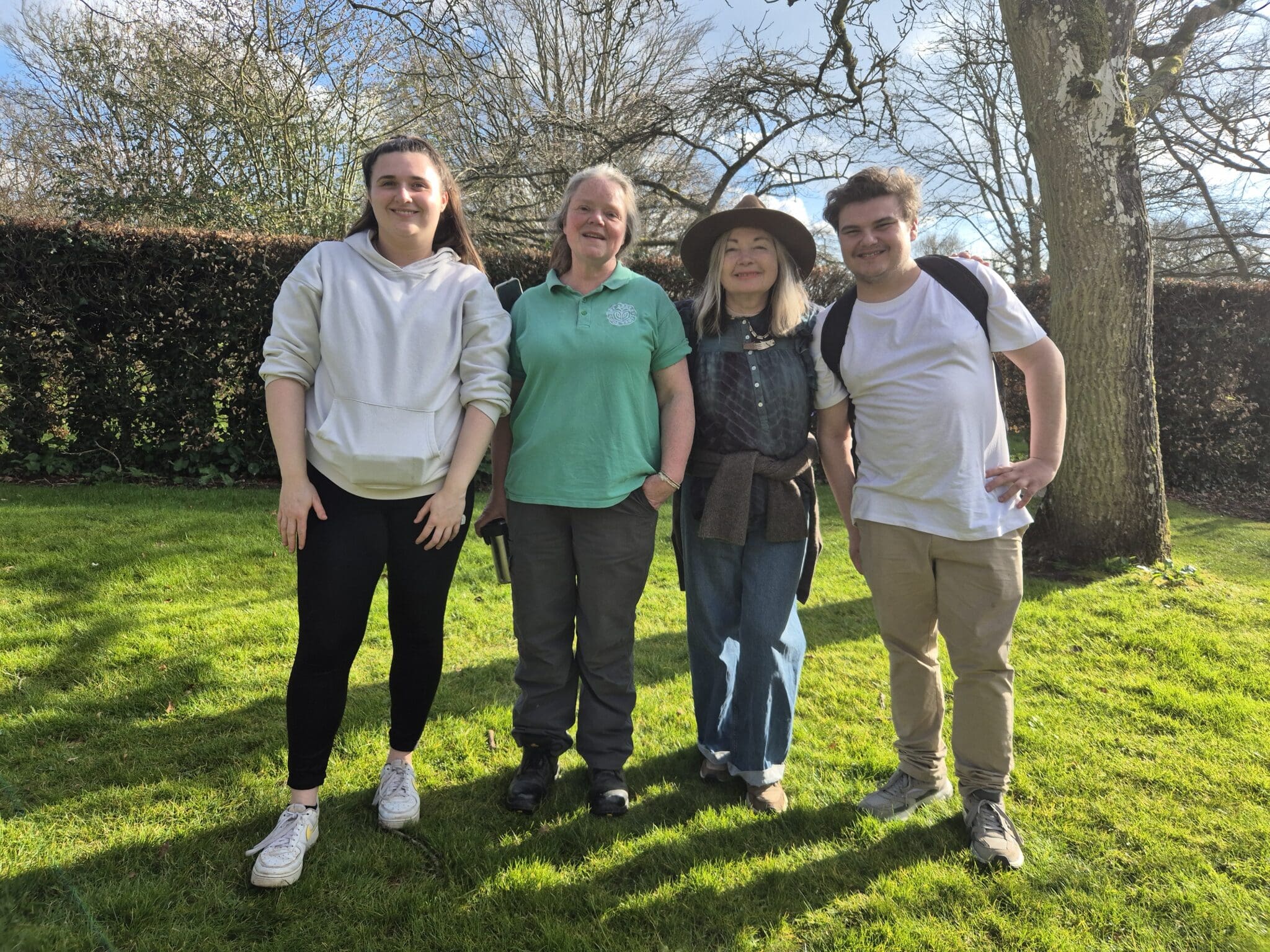 Two young people smile alongside the staff.