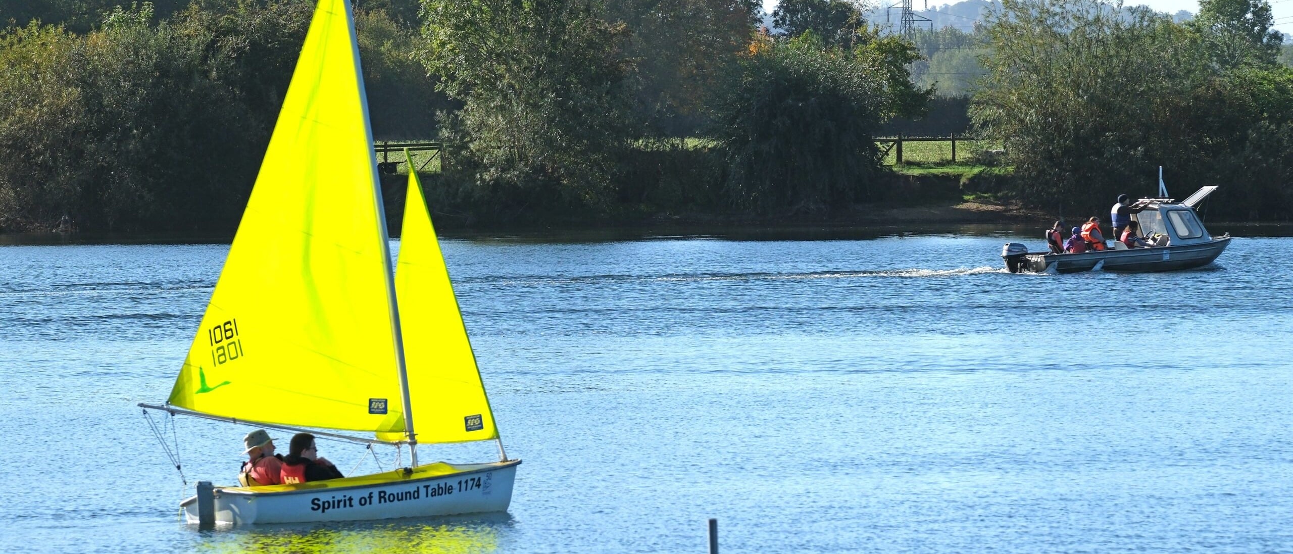 Photo of people enjoying a trip in an accessible sailing dinghy and powerboat on the lake at Frampton on Severn Sailing Club.