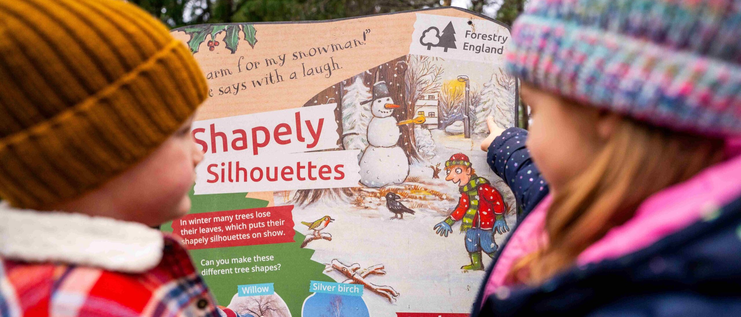 two children look at colourful Stick Man trail panel